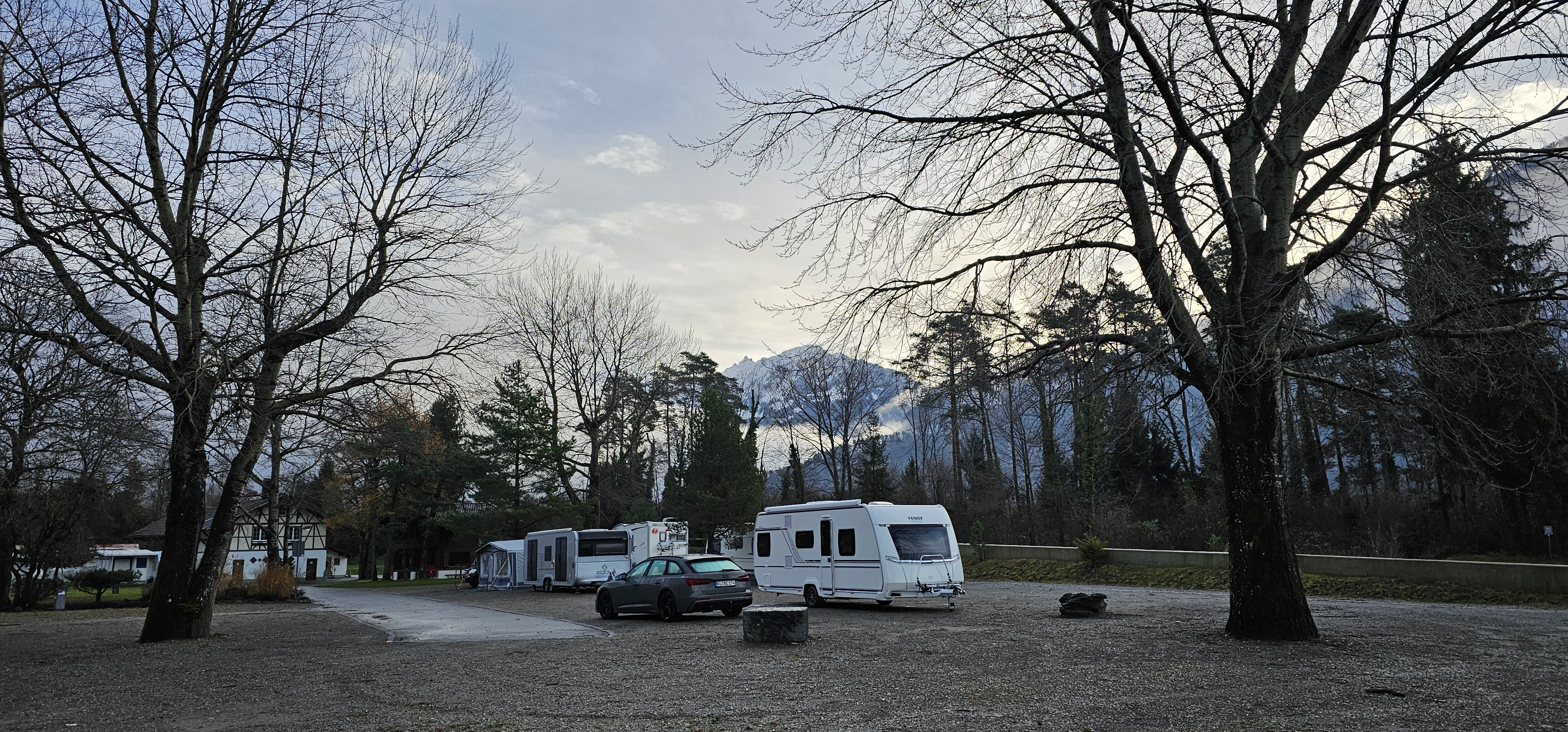 Audi A6 wagon and caravan ready to drive, Lake Thun and clouded Bernese Alps in the background