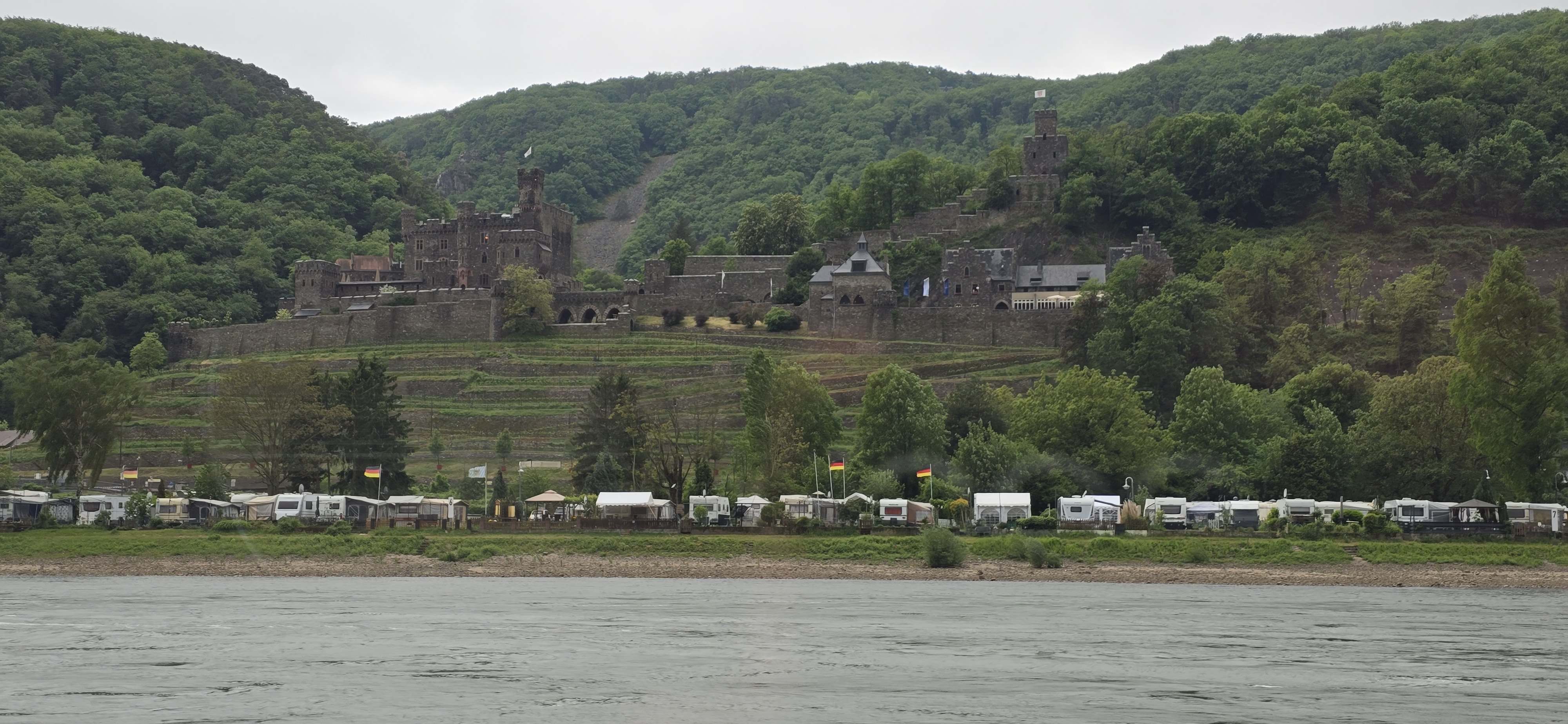Burg Reichenstein at Trechtingshausen seen from the KD Rhine cruise castles boat, Camping-Sonnenstrand caravans on the riverbank below