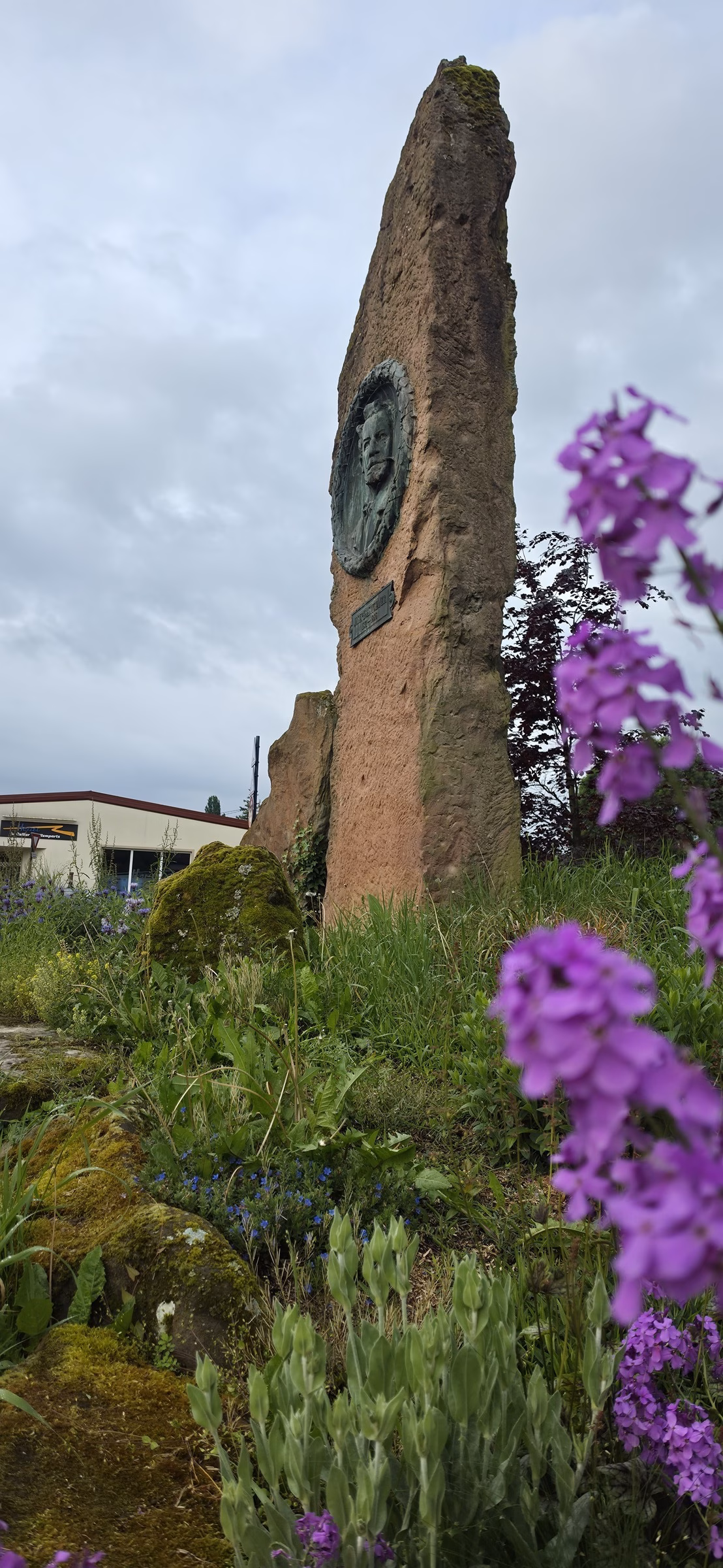 Sandstone stele in the Wissembourg parkland with mid-May purple phlox in the foreground