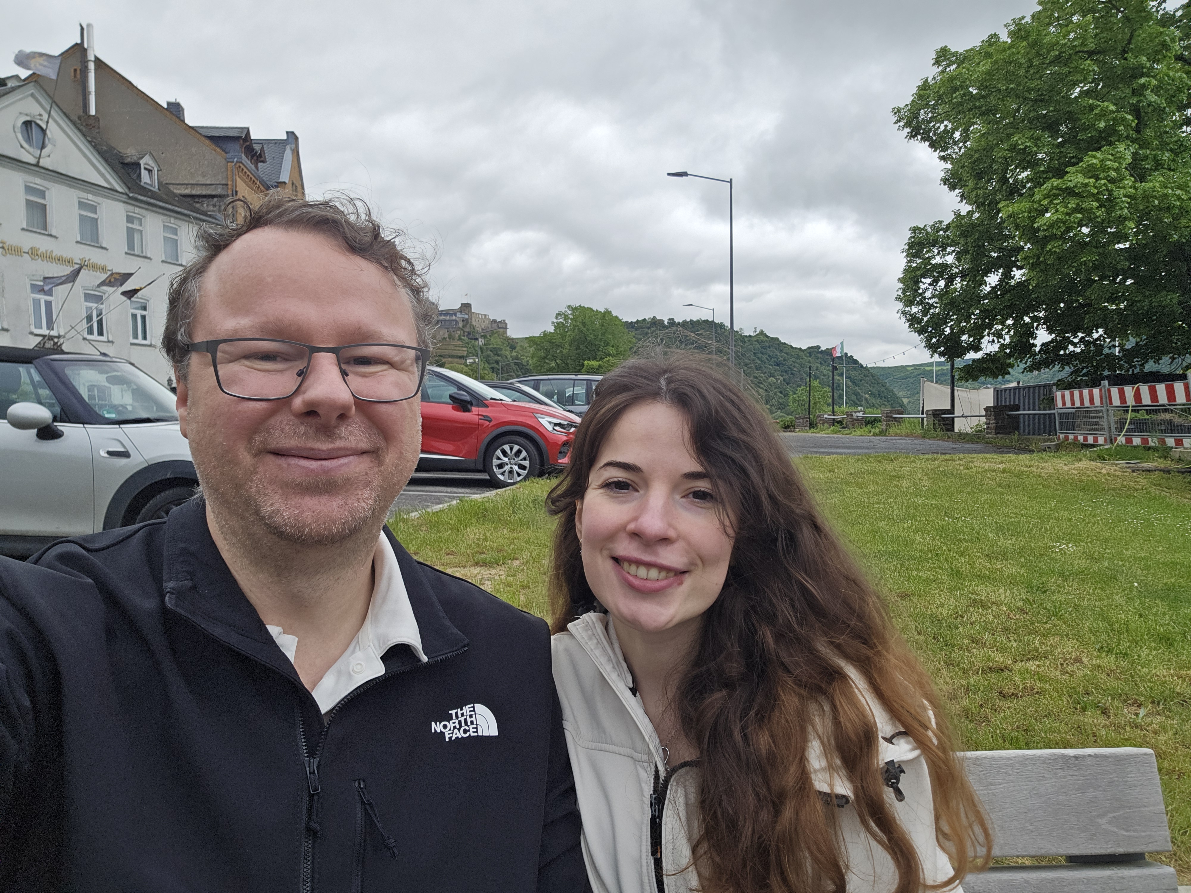 Ryan and Samira on a bench near the St. Goar waterfront in the hour before the 16:10 KD cruise, end of a rainy afternoon
