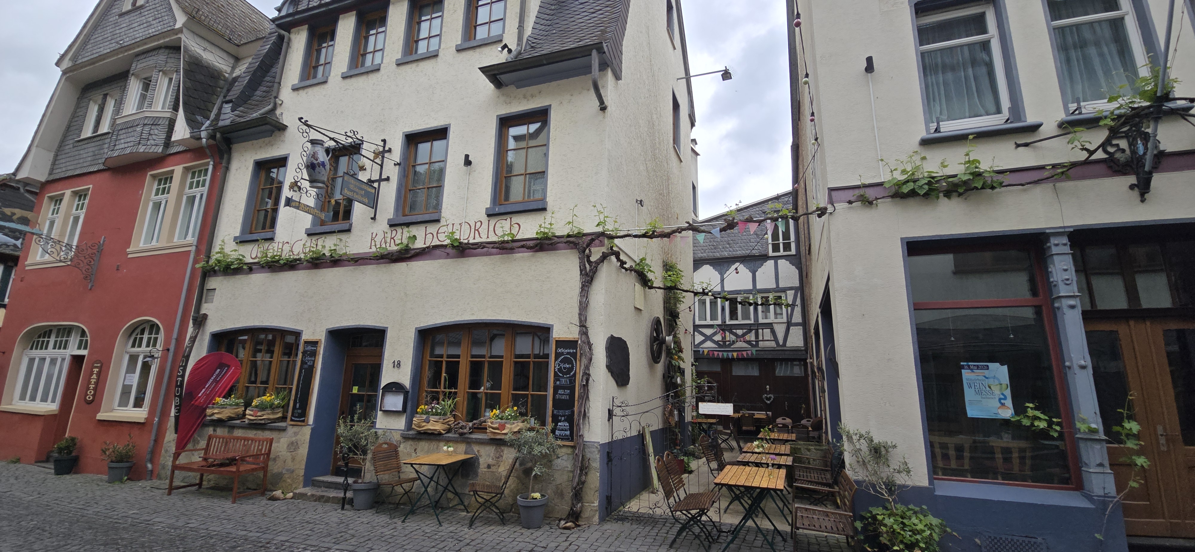 Cafe Karl Heinrich on Oberstraße in Bacharach, wisteria on the facade, outdoor seating on the cobblestone street