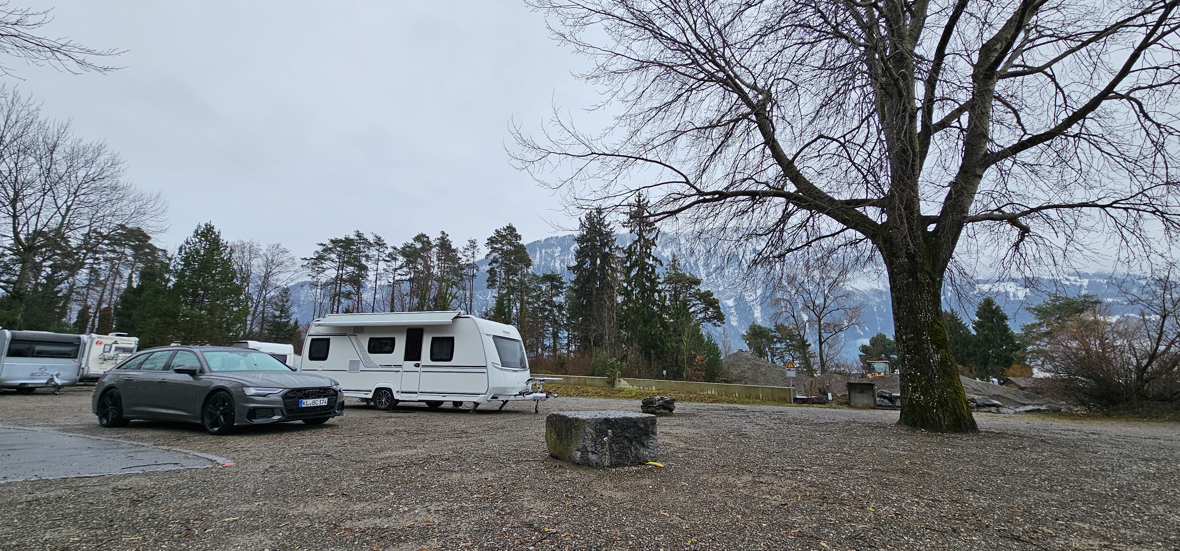 Pulling back from the pitch at Nublatze, two caravans visible at left, Audi in the gap with the picnic-bench stone in the middle