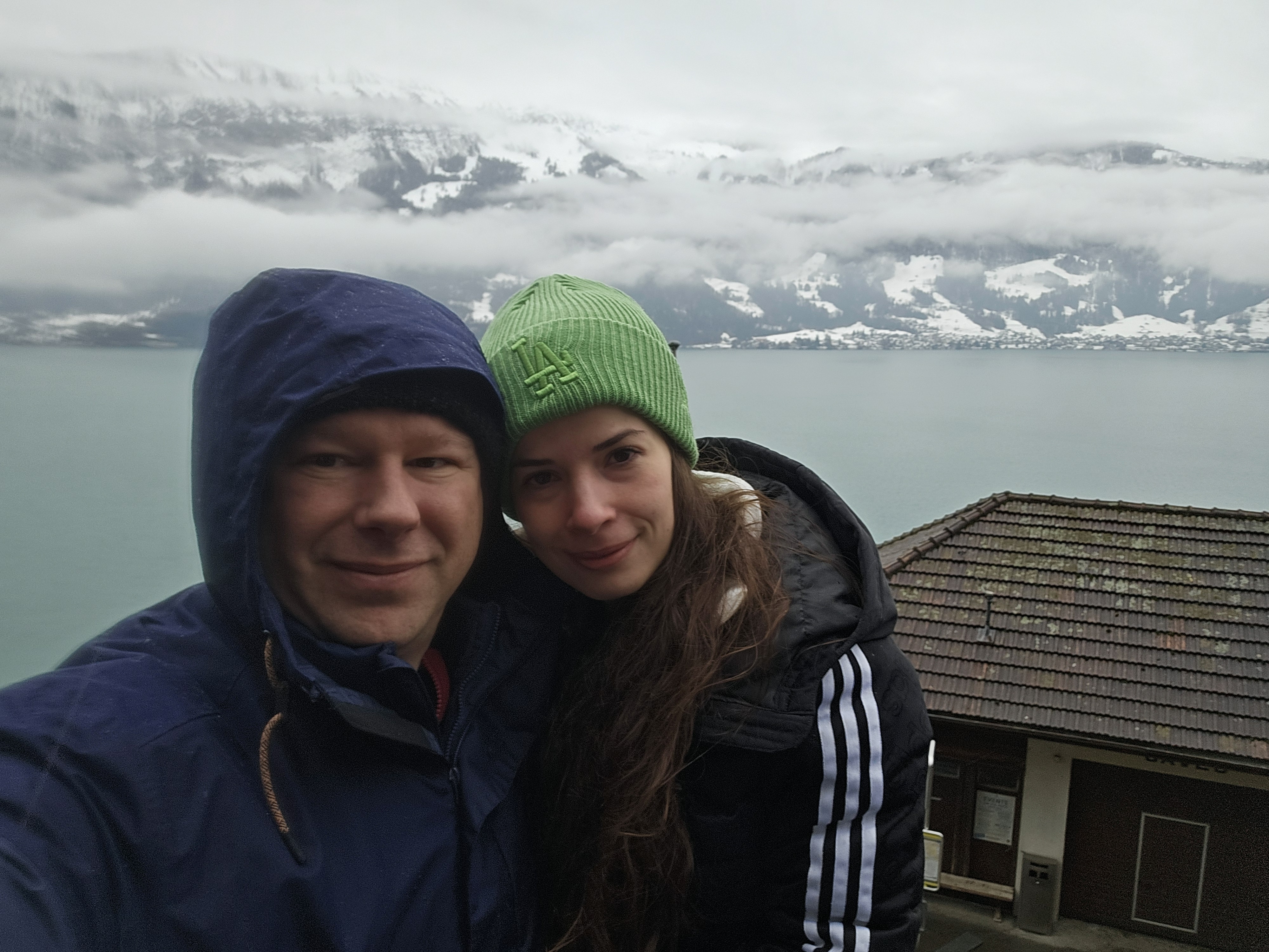 Ryan and Samira at the St. Beatus Caves terrace railing, the view out over Lake Thun