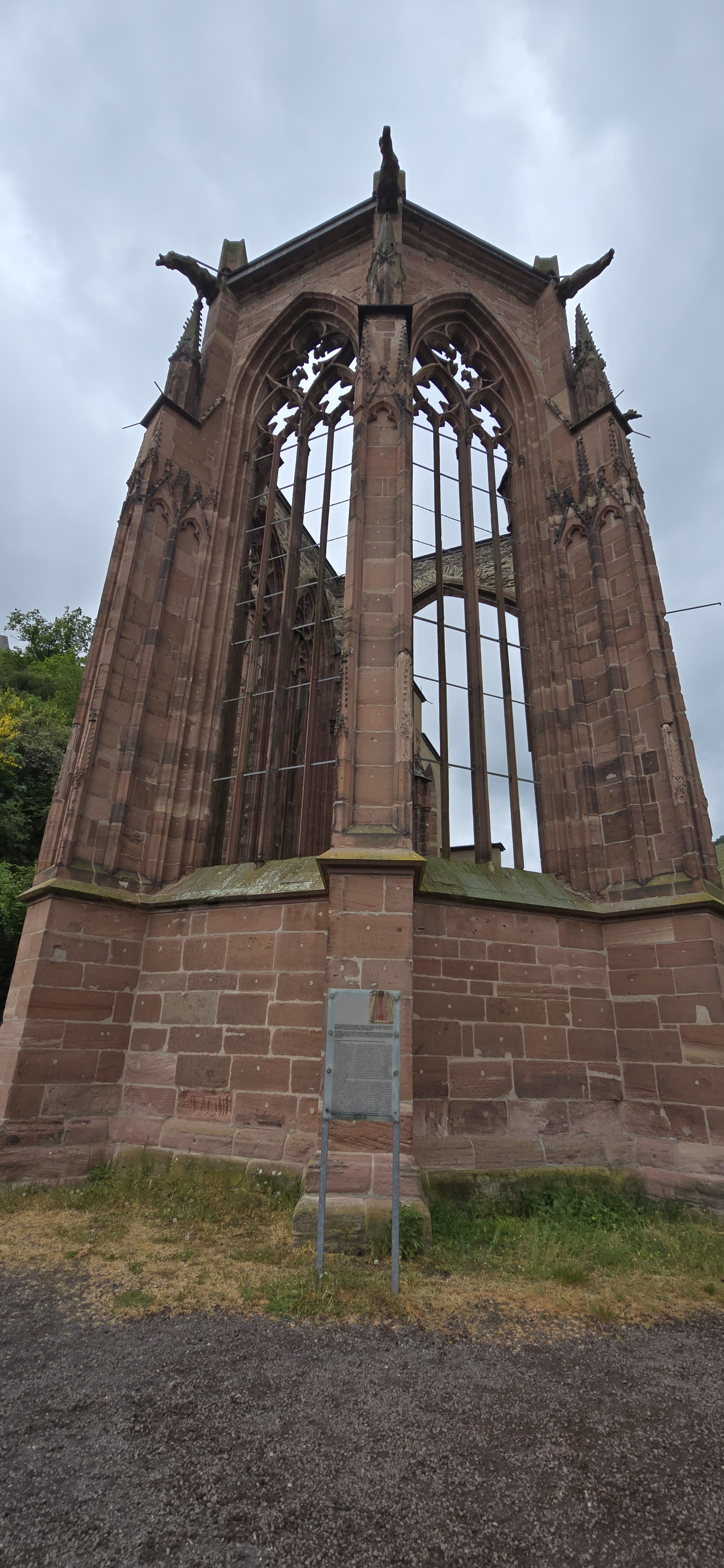 Wernerkapelle Gothic ruin exterior seen from below the terrace in Bacharach, sandstone tracery against overcast sky