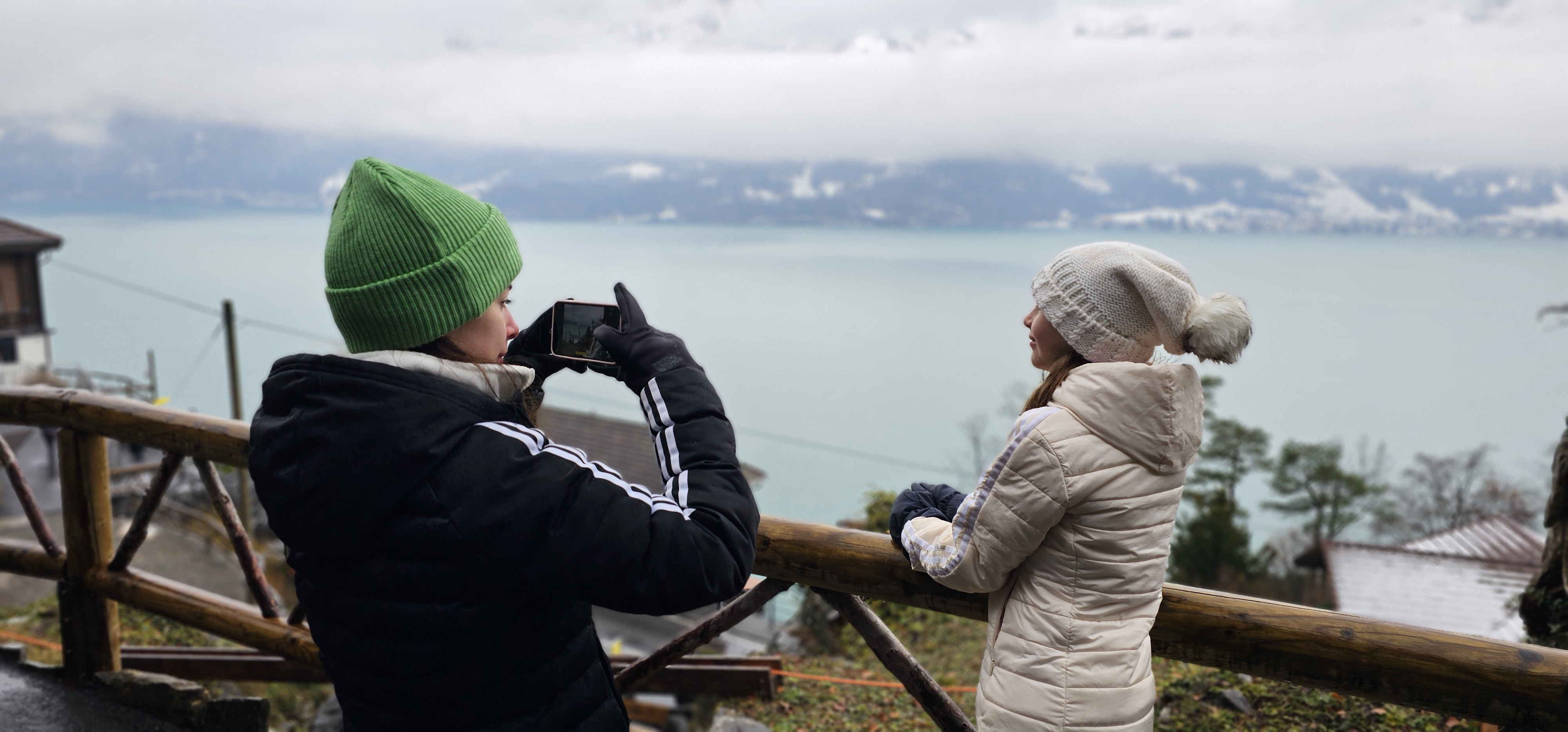 Samira photographing Sahryah on the cave-park railing, Lake Thun behind