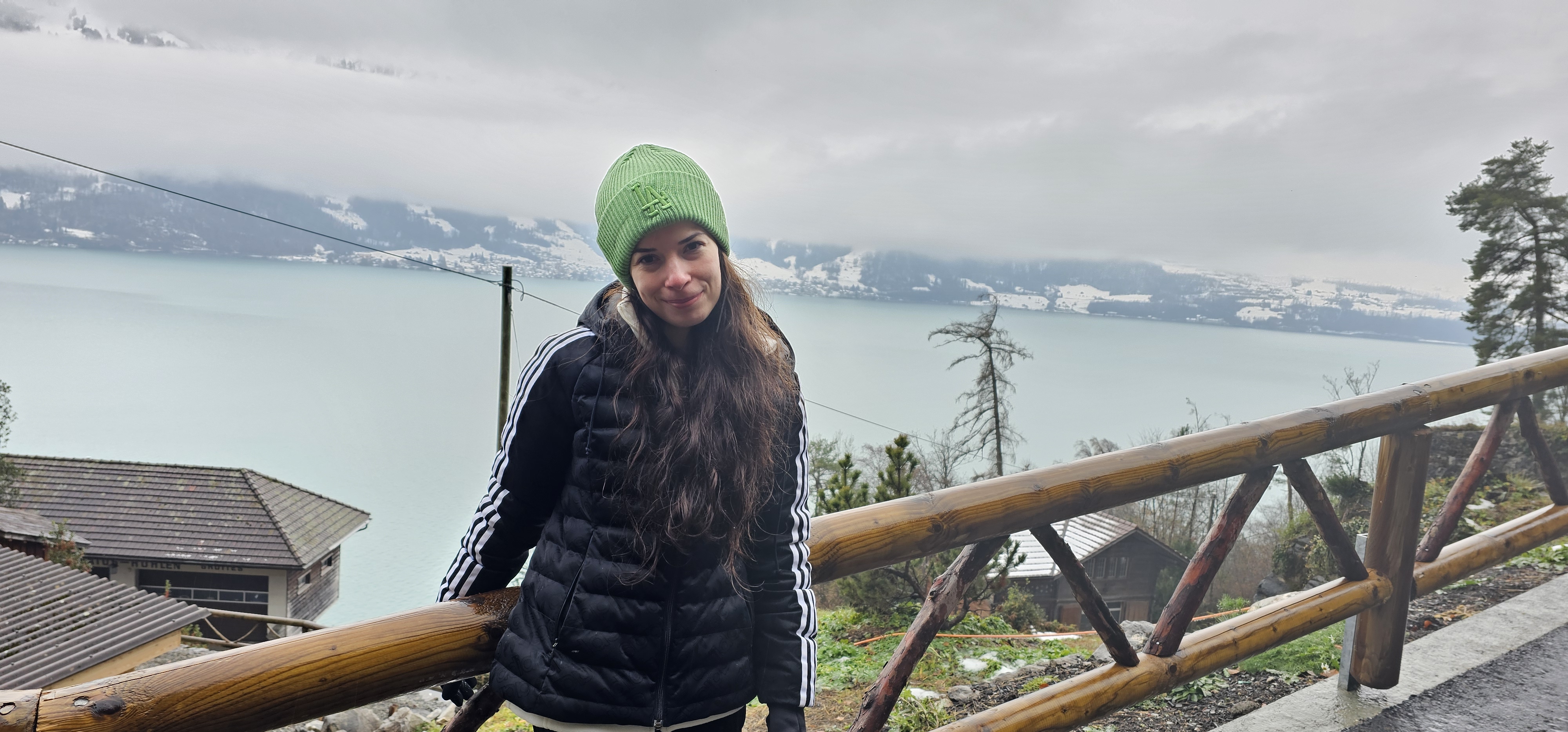Samira at the cave-park terrace railing with the view over Lake Thun