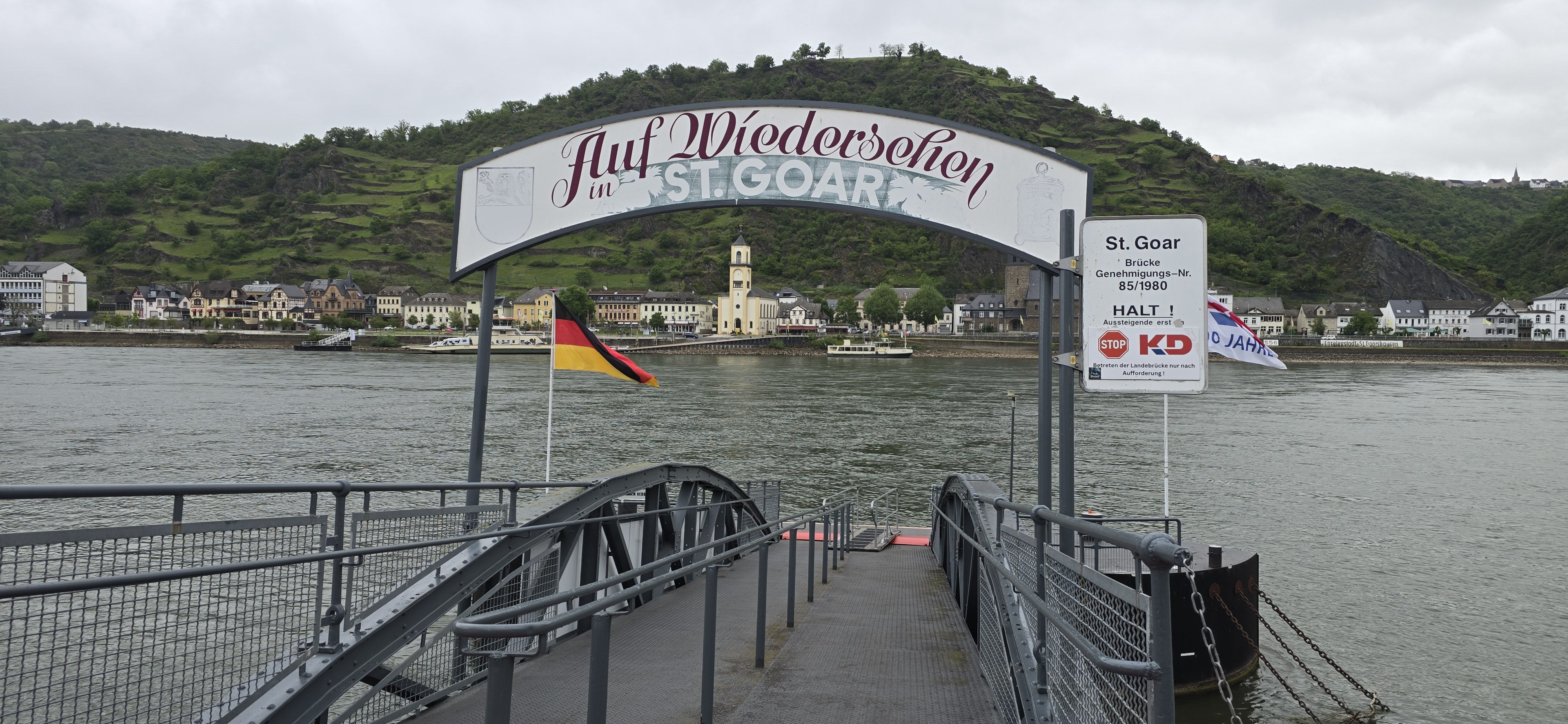 Auf Wiedersehen in St. Goar arch sign at the KD boarding dock, looking across the Rhine to St. Goarshausen