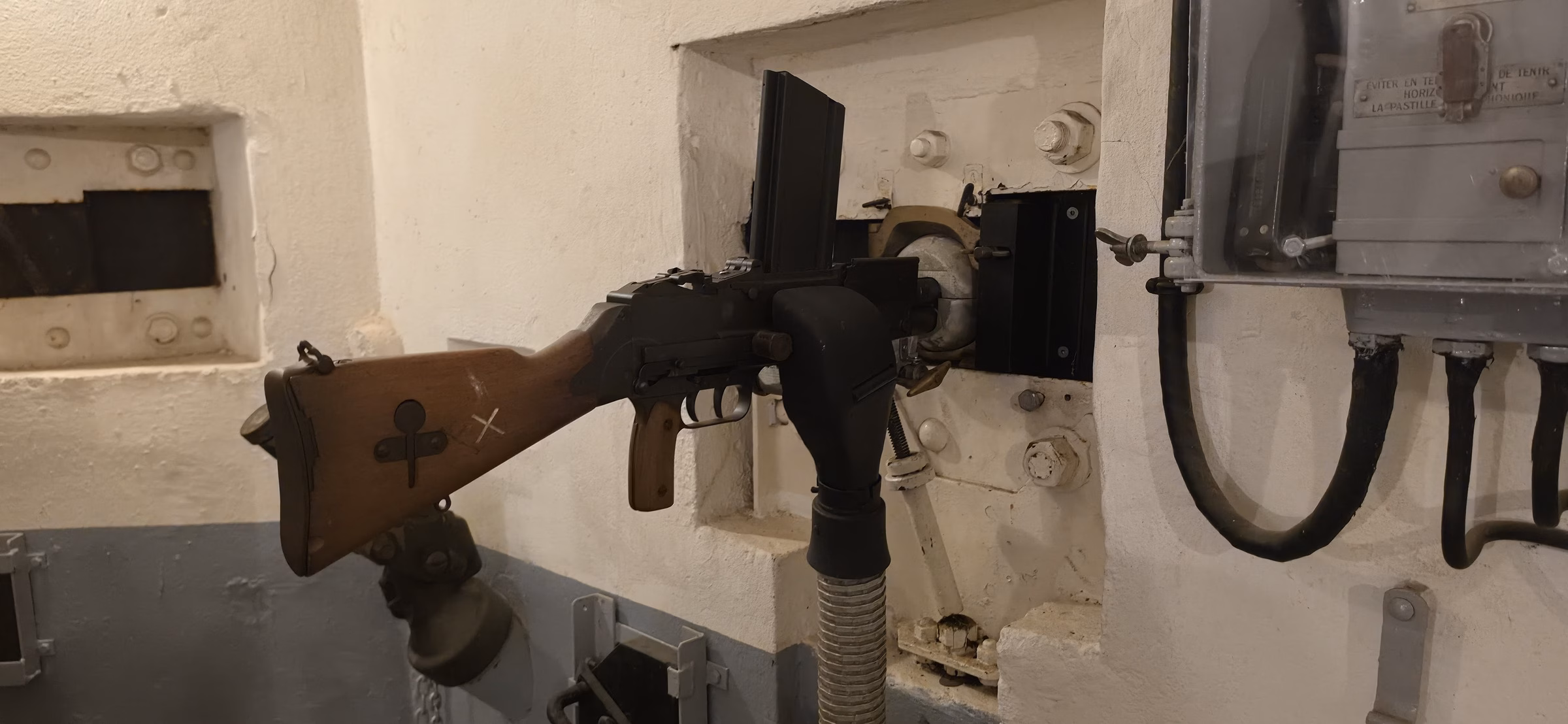 Original 1930s machine-gun mount on a wooden stock inside a Schoenenbourg combat block, with armored steel walls