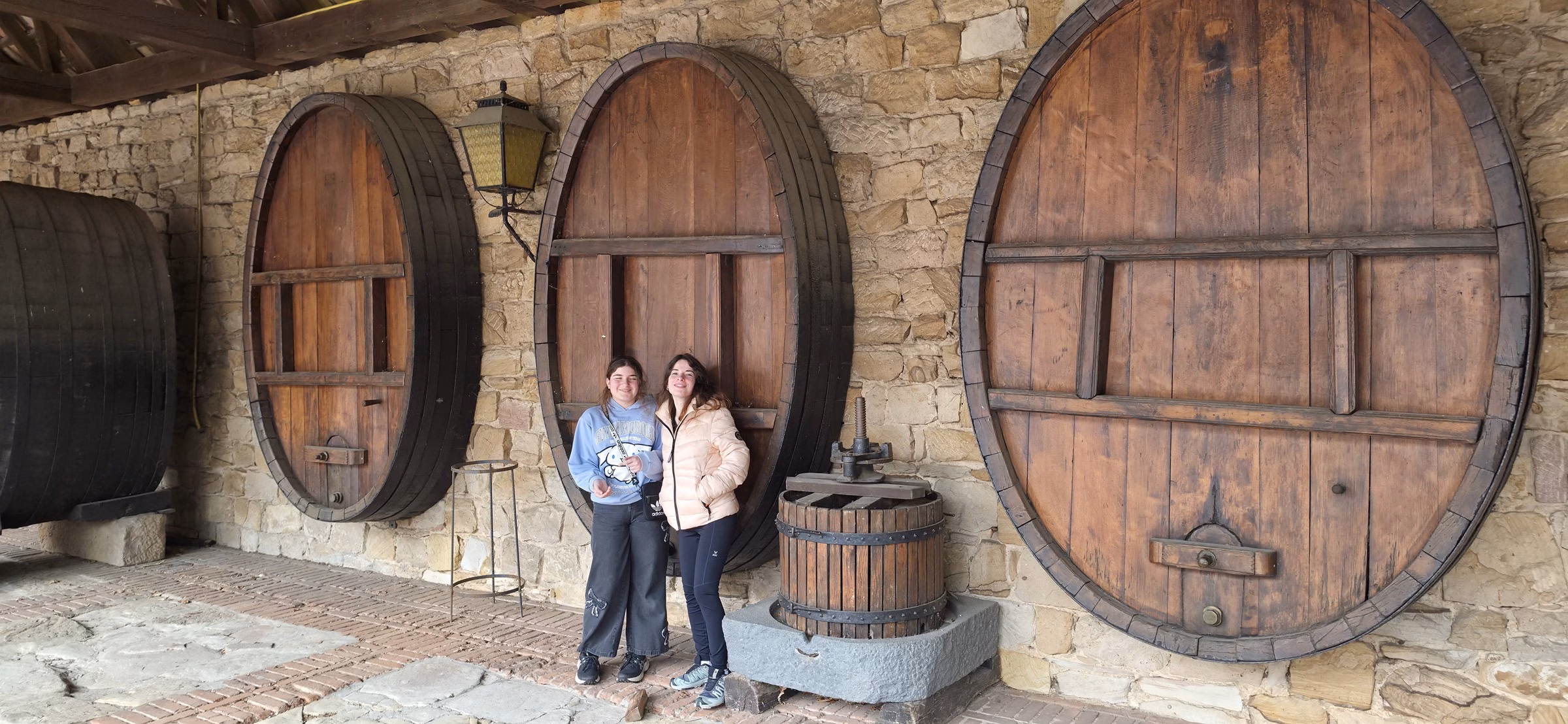 Family standing next to the giant Fuder wine barrels in the Weintor cellar to show scale
