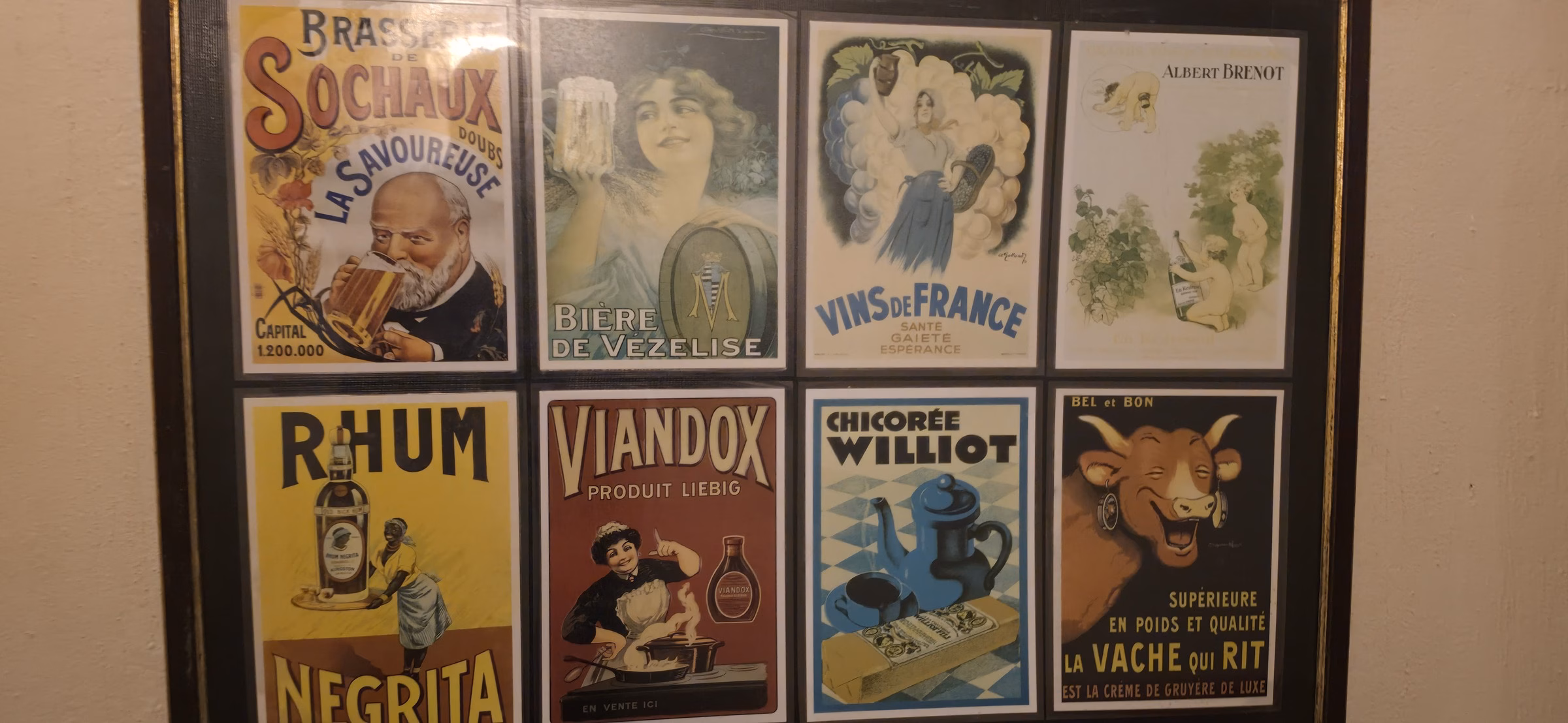 Eight framed vintage 1930s French advertising posters mounted on a Schoenenbourg barracks wall, including RHUM Negrita and VIANDOX