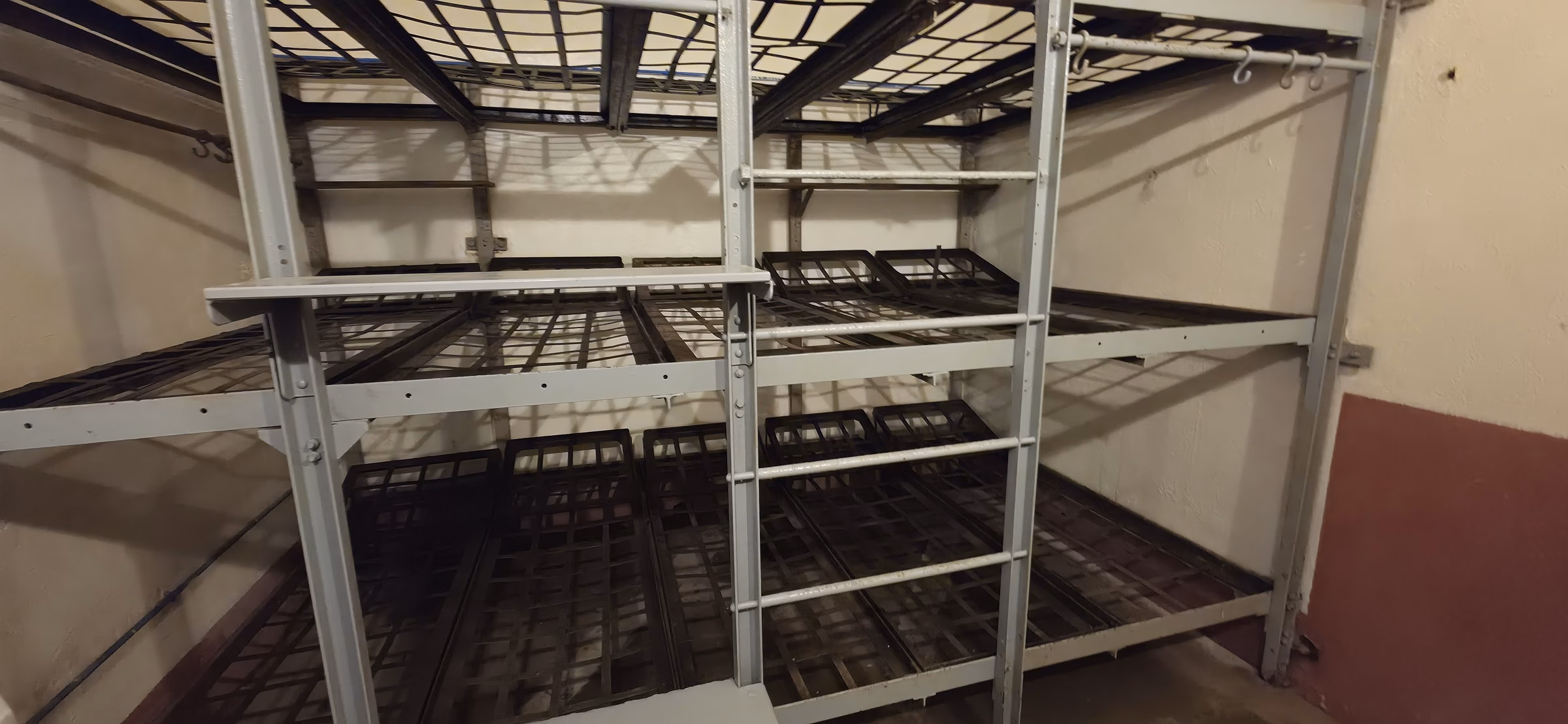 Metal-frame bunk beds stacked in the barracks of Fort Schoenenbourg