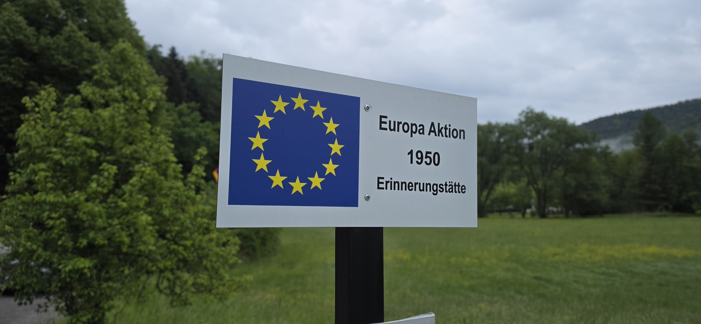 Yellow directional sign with EU stars reading Europa Aktion 1950 Erinnerungsstätte pointing to the Europa-Denkmal from the L 478 in Sankt Germanshof