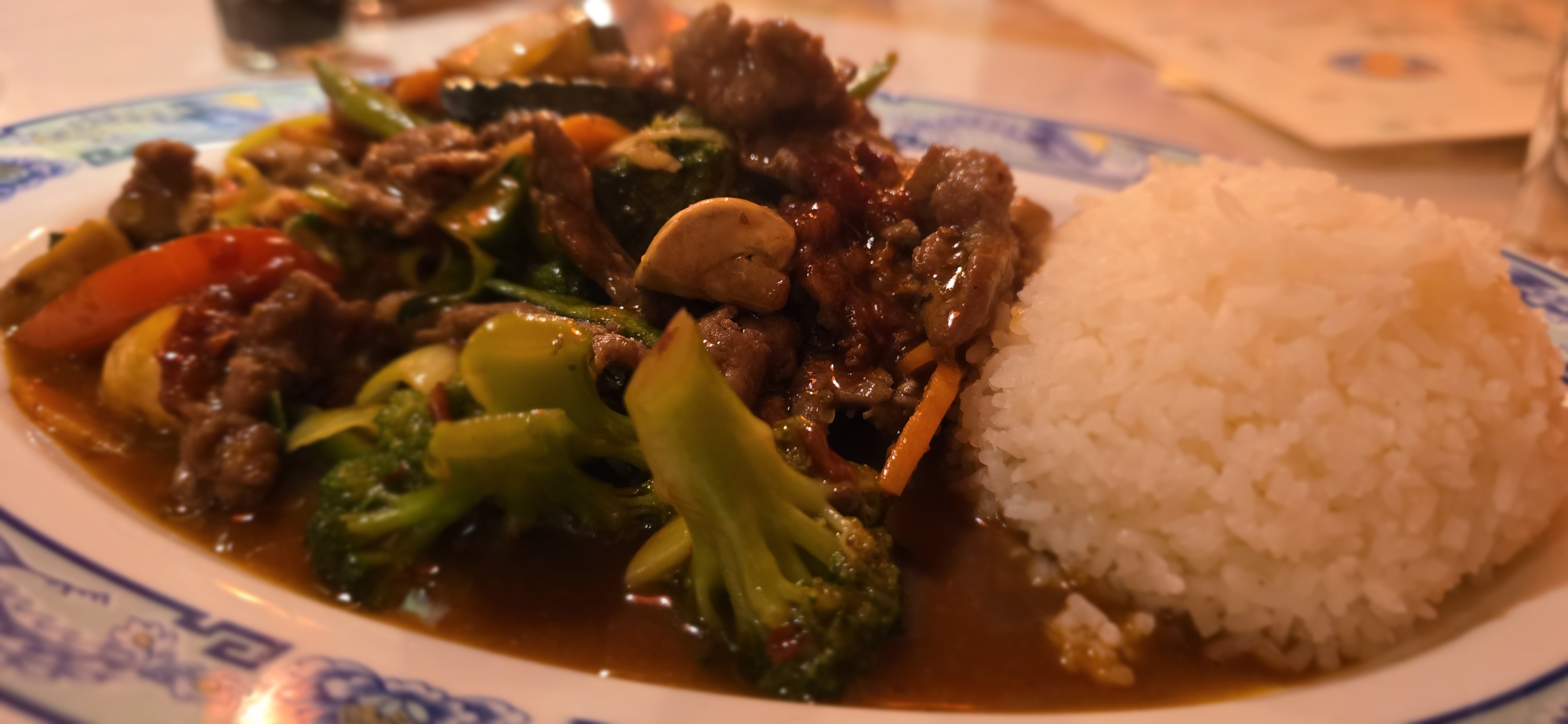 Beef-broccoli plate at Asia Kim St. Goar in a vaulted cellar room with warm tungsten lighting