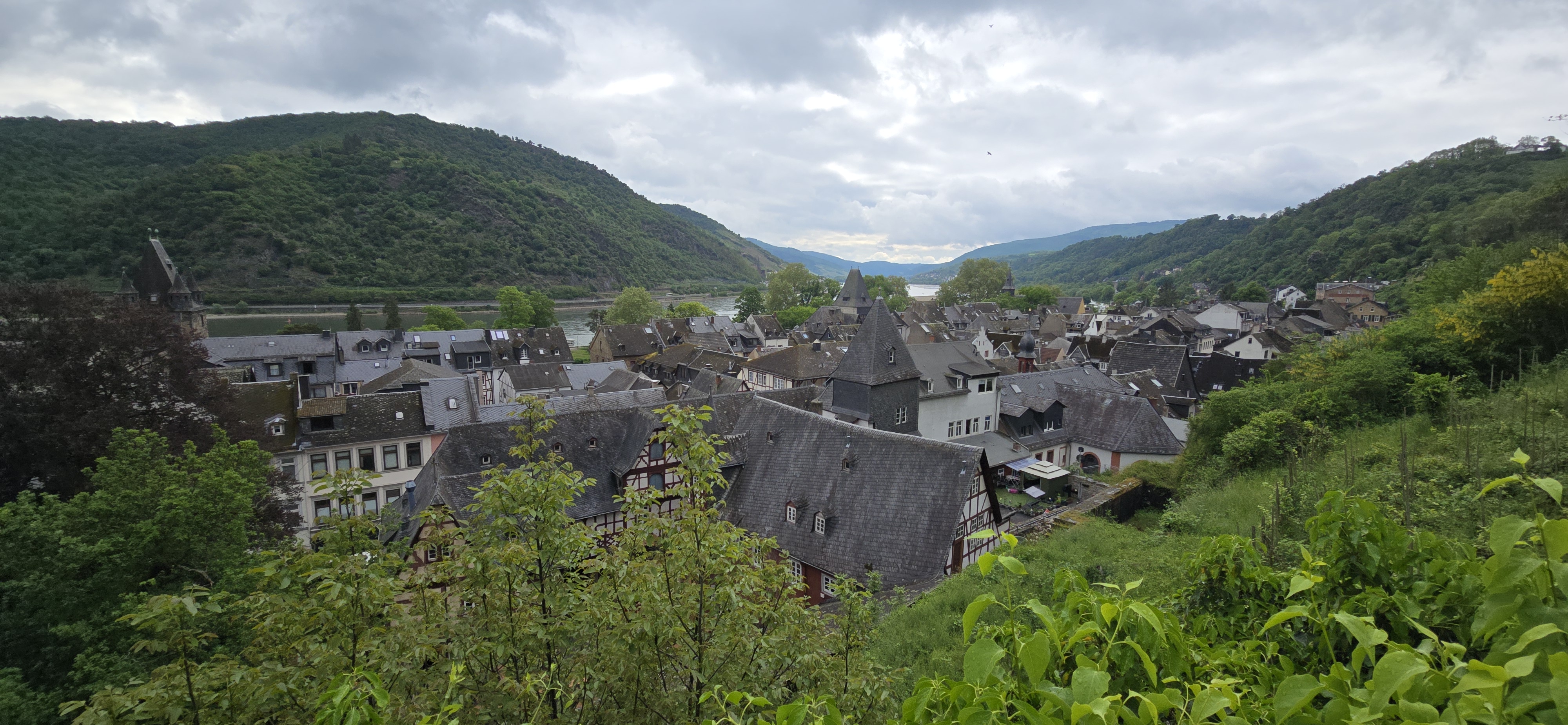 Panoramic view over Bacharach rooftops toward the Rhine valley from the town wall, Burg Stahleck ridge visible above