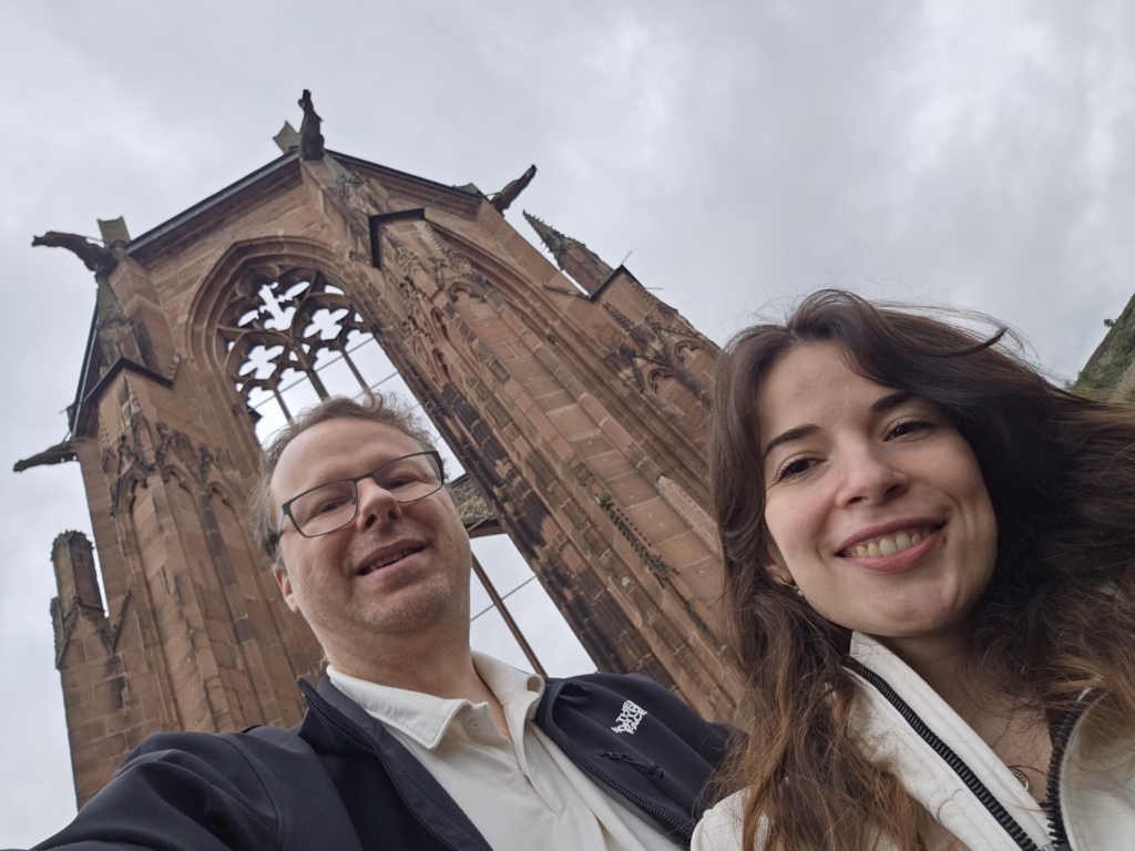Ryan and Samira below the roofless red-sandstone Gothic ruin of the Werner Chapel above Bacharach