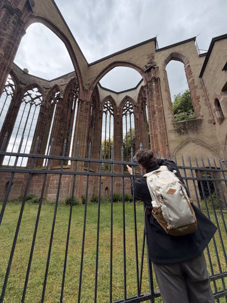 Ryan standing inside the roofless Werner Chapel looking up at the open Gothic window tracery