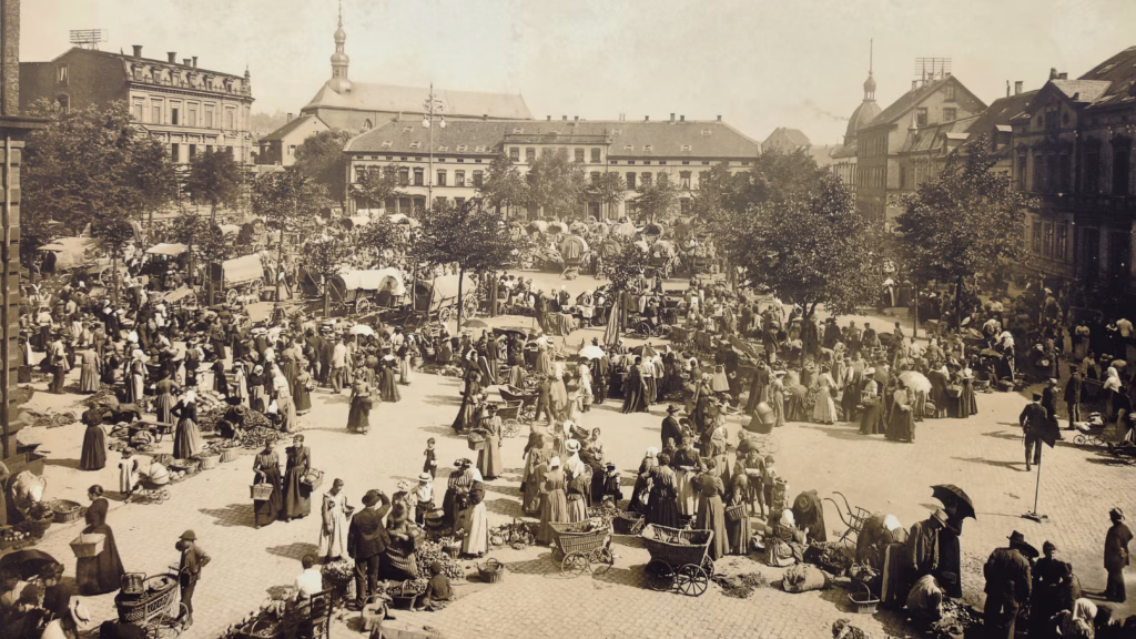 Late-19th-century Stiftsplatz market day, from the Kaiserslautern 750 anniversary display panels: vendors and carts in front of the Stiftskirche